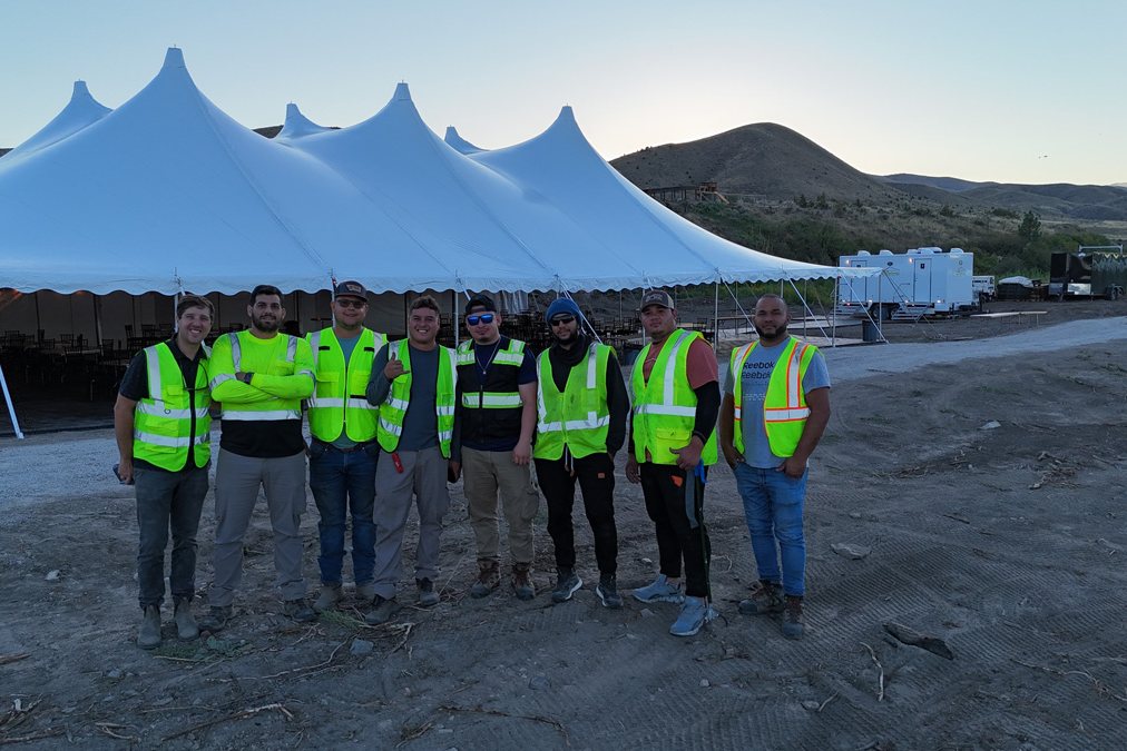 Big Sky Site Services crew in safety vests in front of a large event tent