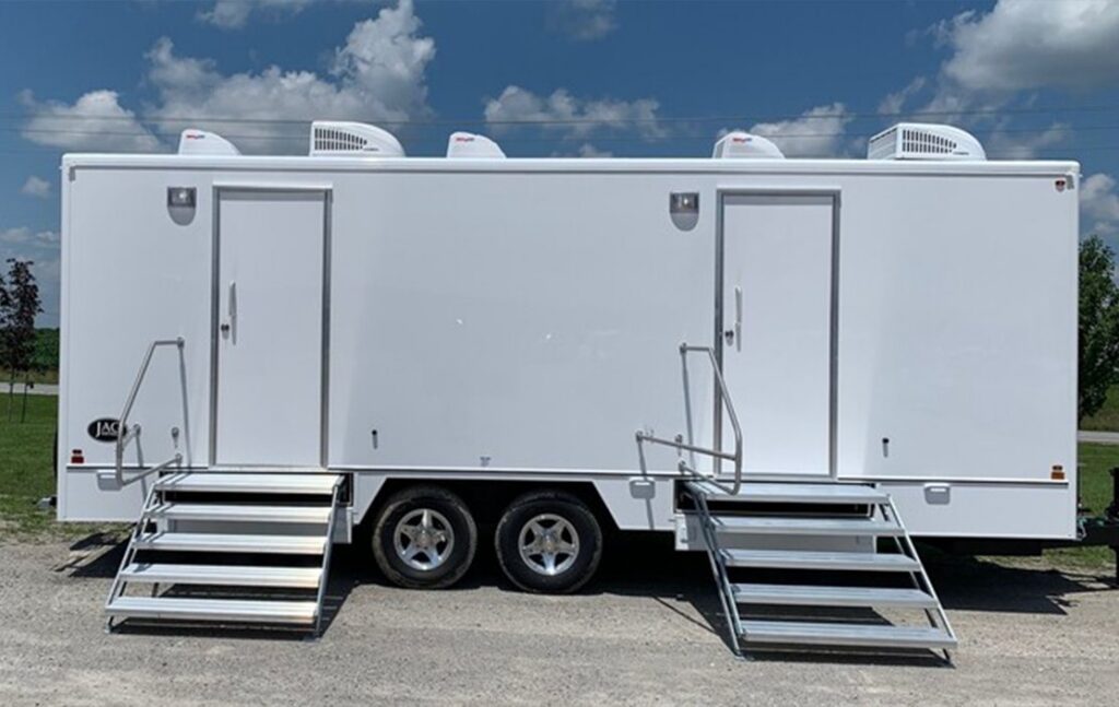 White mobile laundry trailer with two doors and metal steps
